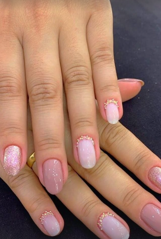 Nail art em tons nude e rosa com brilho e detalhes dourados